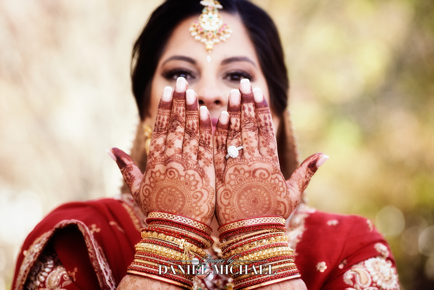 Bride with intricate henna designs on her hands during an Indian wedding ceremony